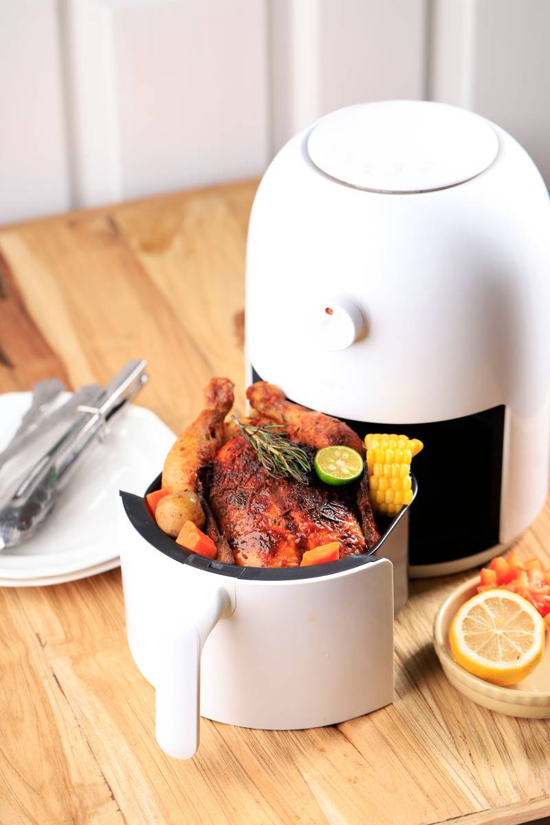 Homemade Roasted Whole Chicken with Lemon, Rosemary, Vegetable on Air Fryer. Copy Space for Text