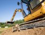 Mini excavator digging preparing ground under home garden